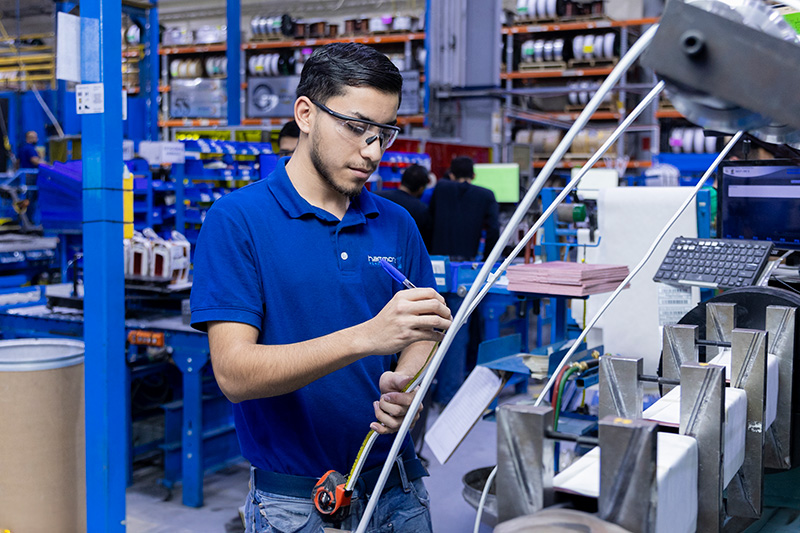factory technician measures transformer component